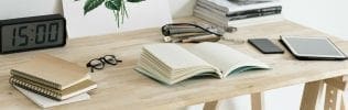 Bureau met boeken, klok en tablet