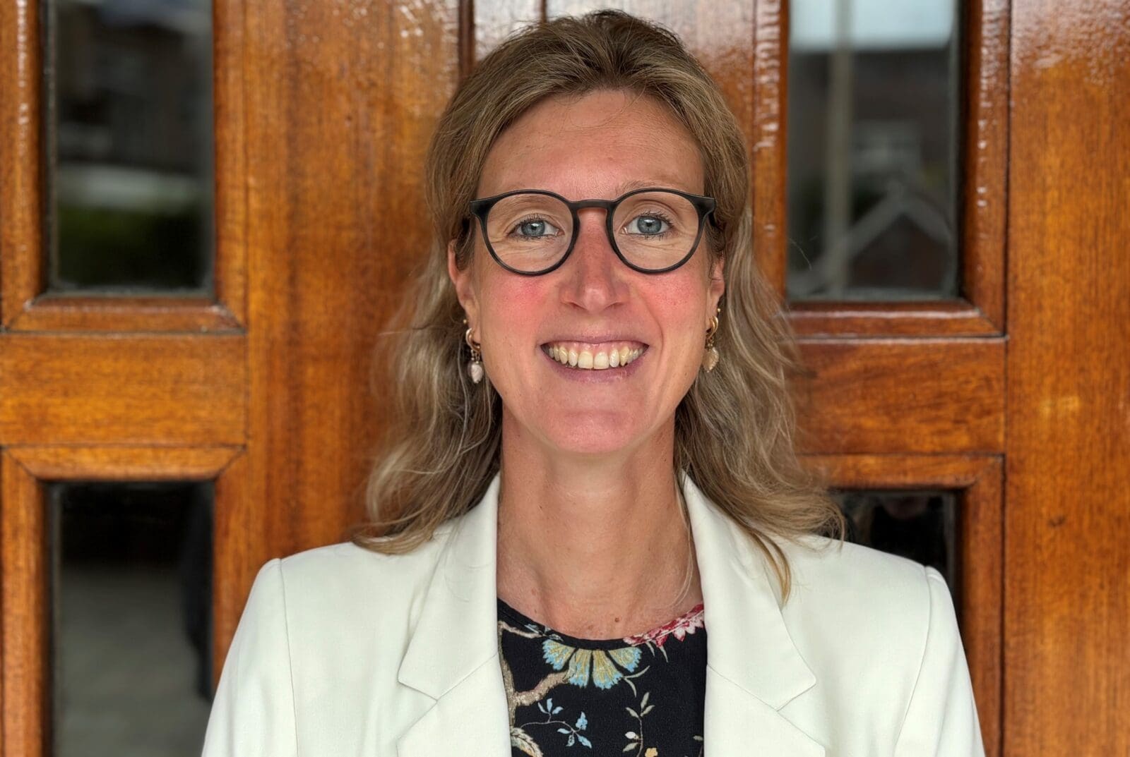 Portret van een vrouw met bril voor houten deur.