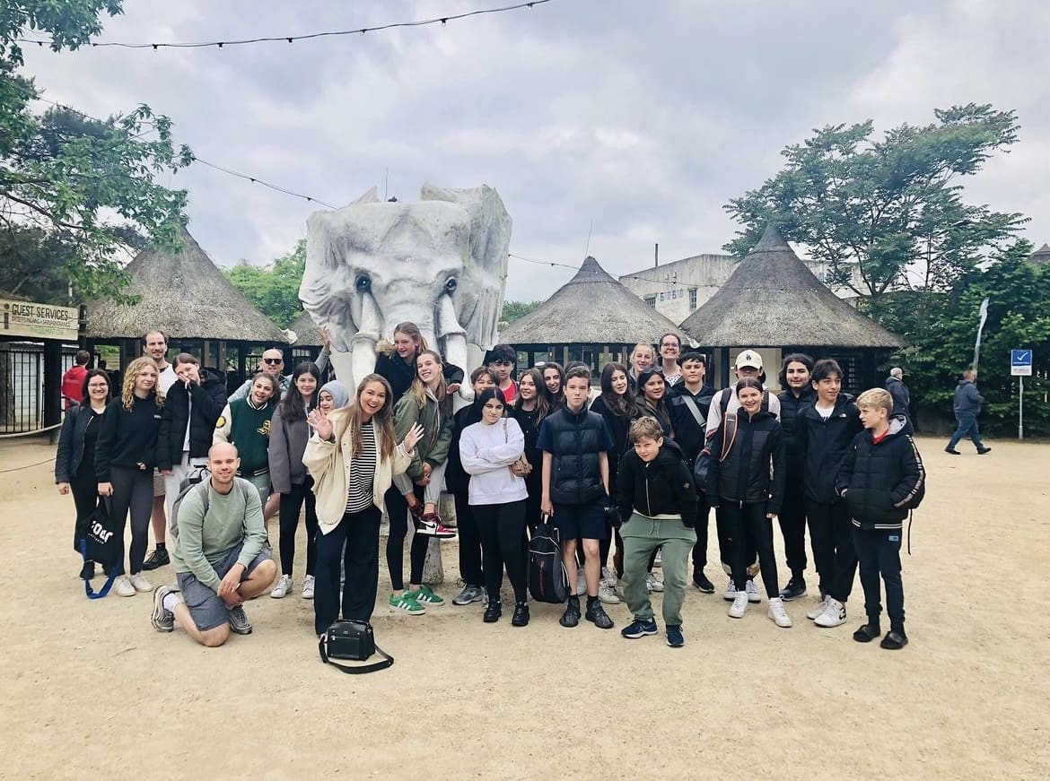 Groep studenten en docenten voor een olifantenbeeld in Beekse Bergen.