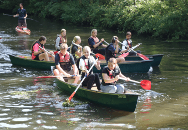 Studenten van Luzac Amersfoort kanoën op een rivier.