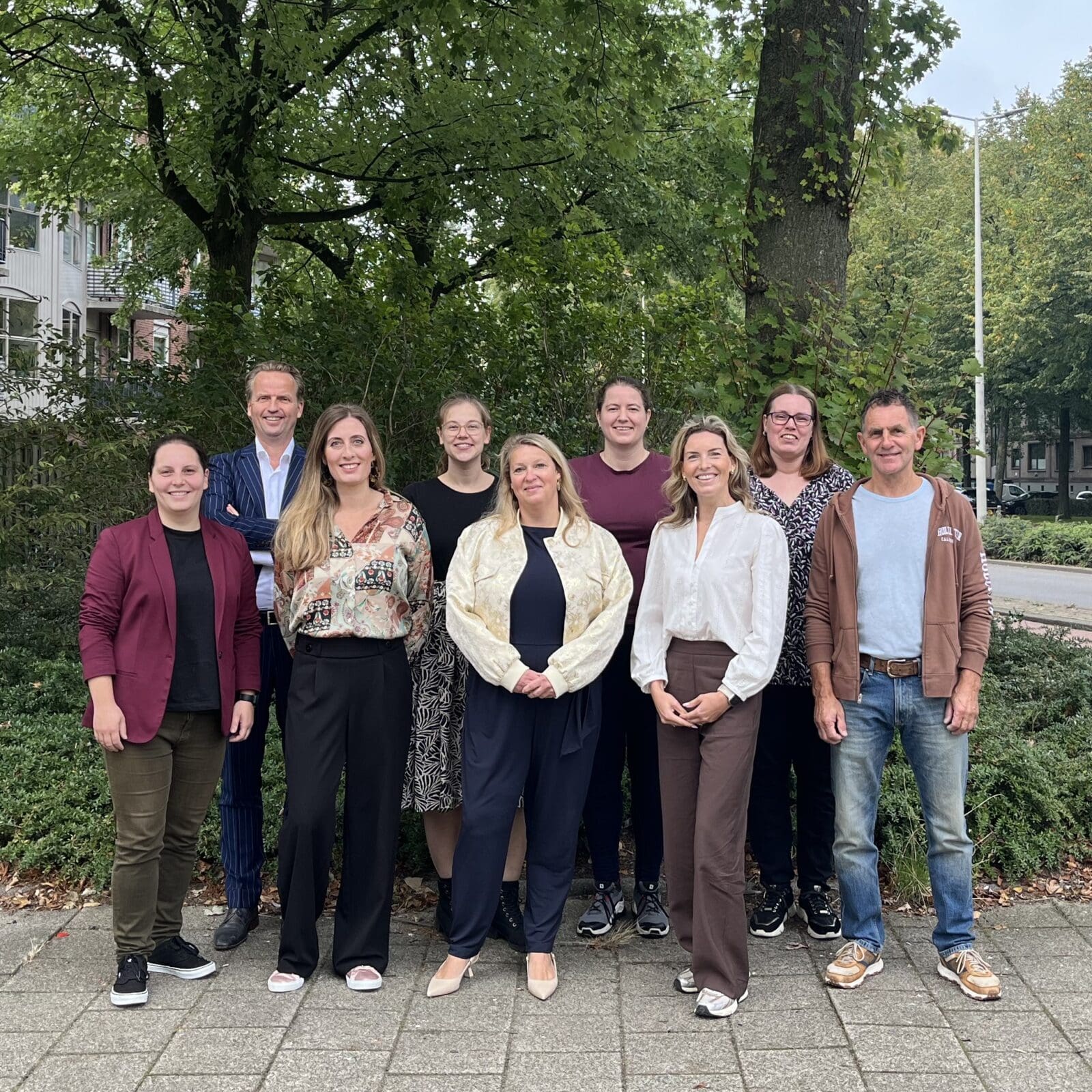 Team Luzac Rotterdam poseert voor een groepsfoto buiten.