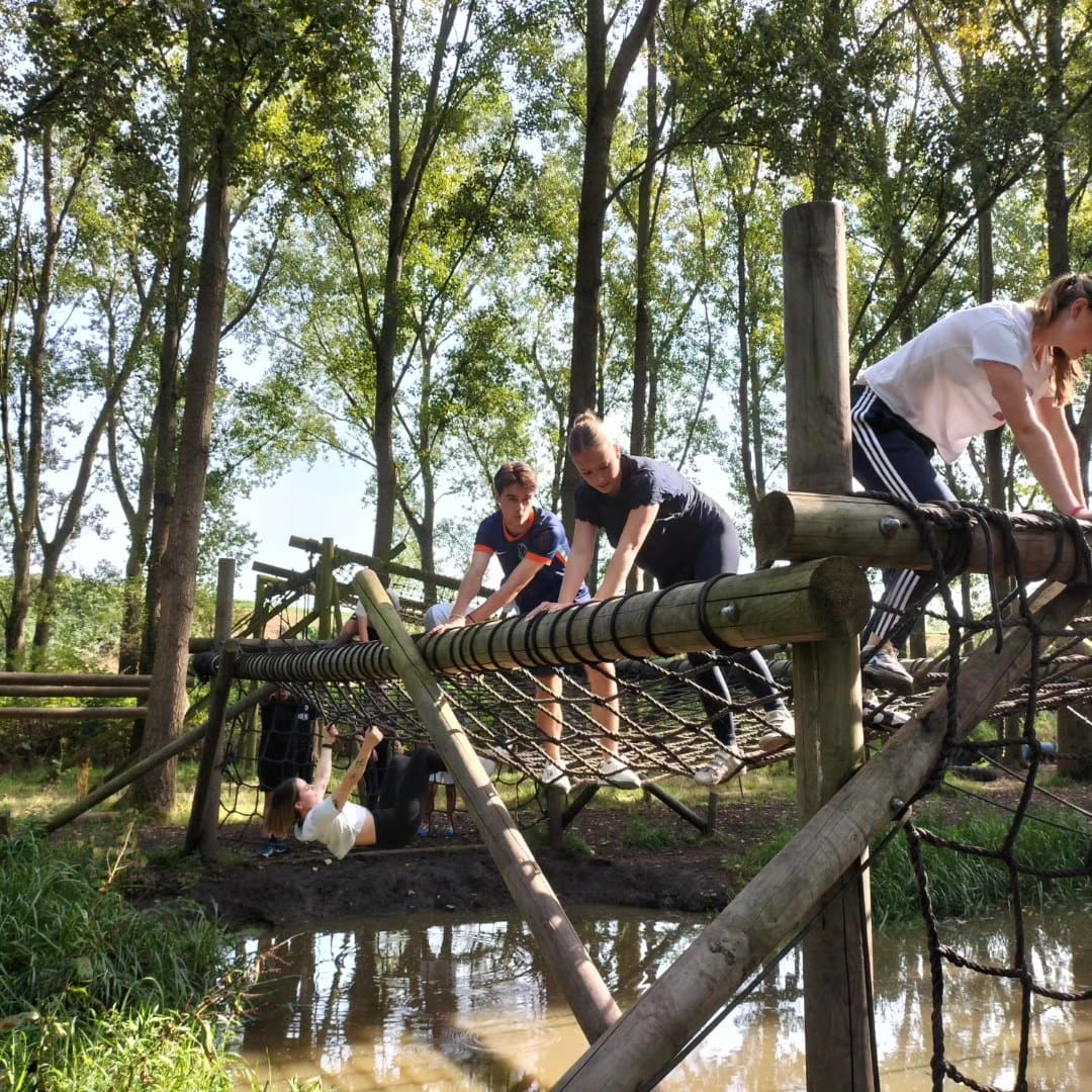 Leerlingen op een touwbrug tijdens een introductiedag.
