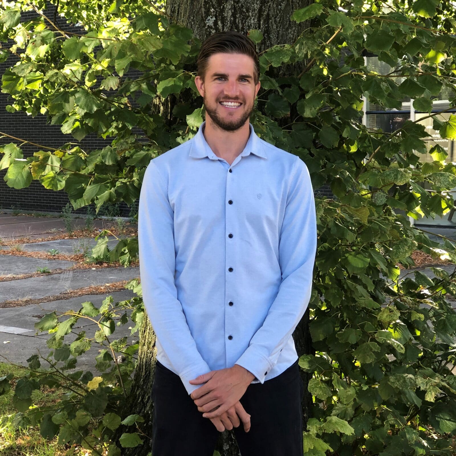 Portret van een man voor een boom.