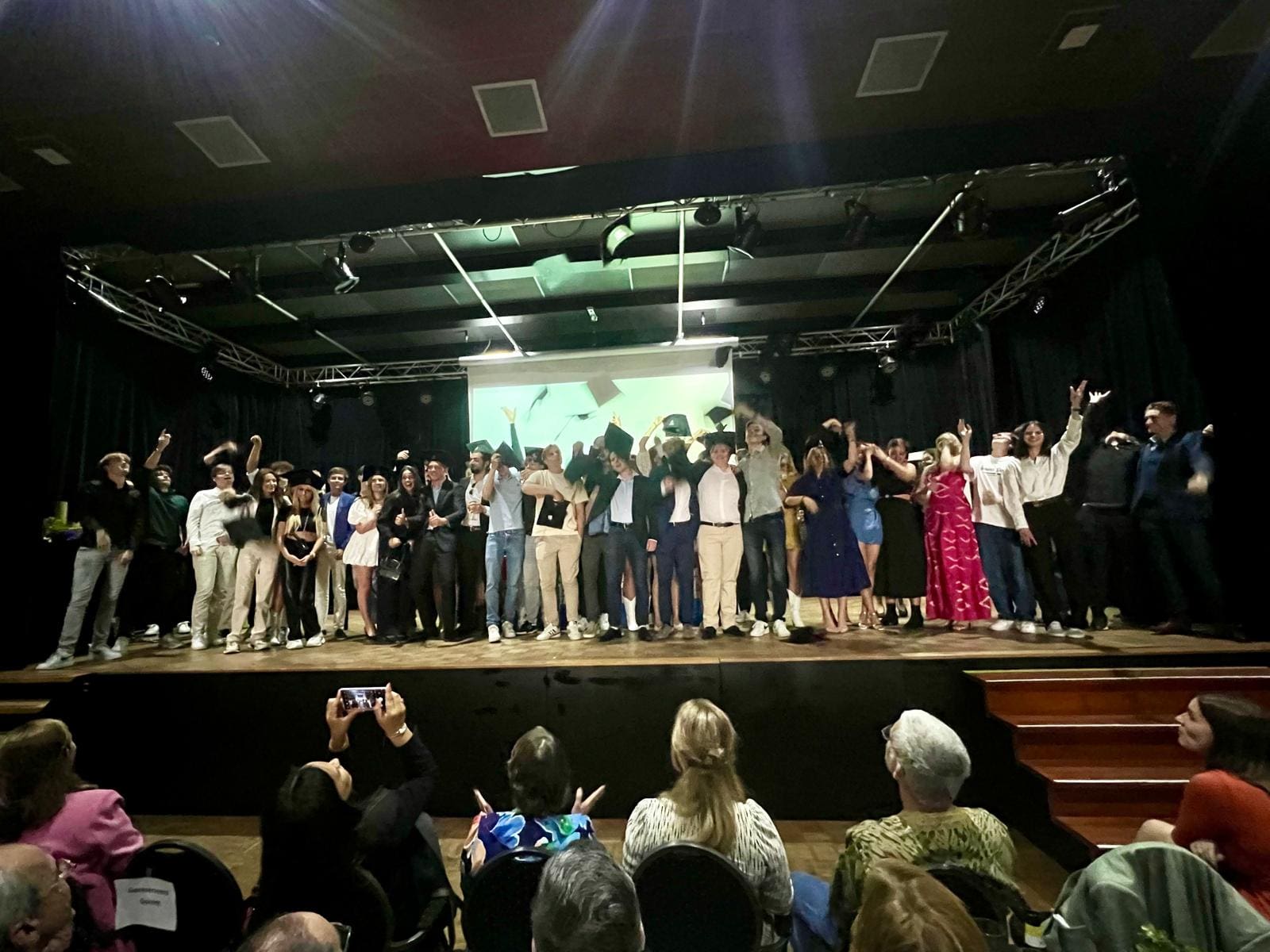 Diploma-uitreiking van studenten op een podium.