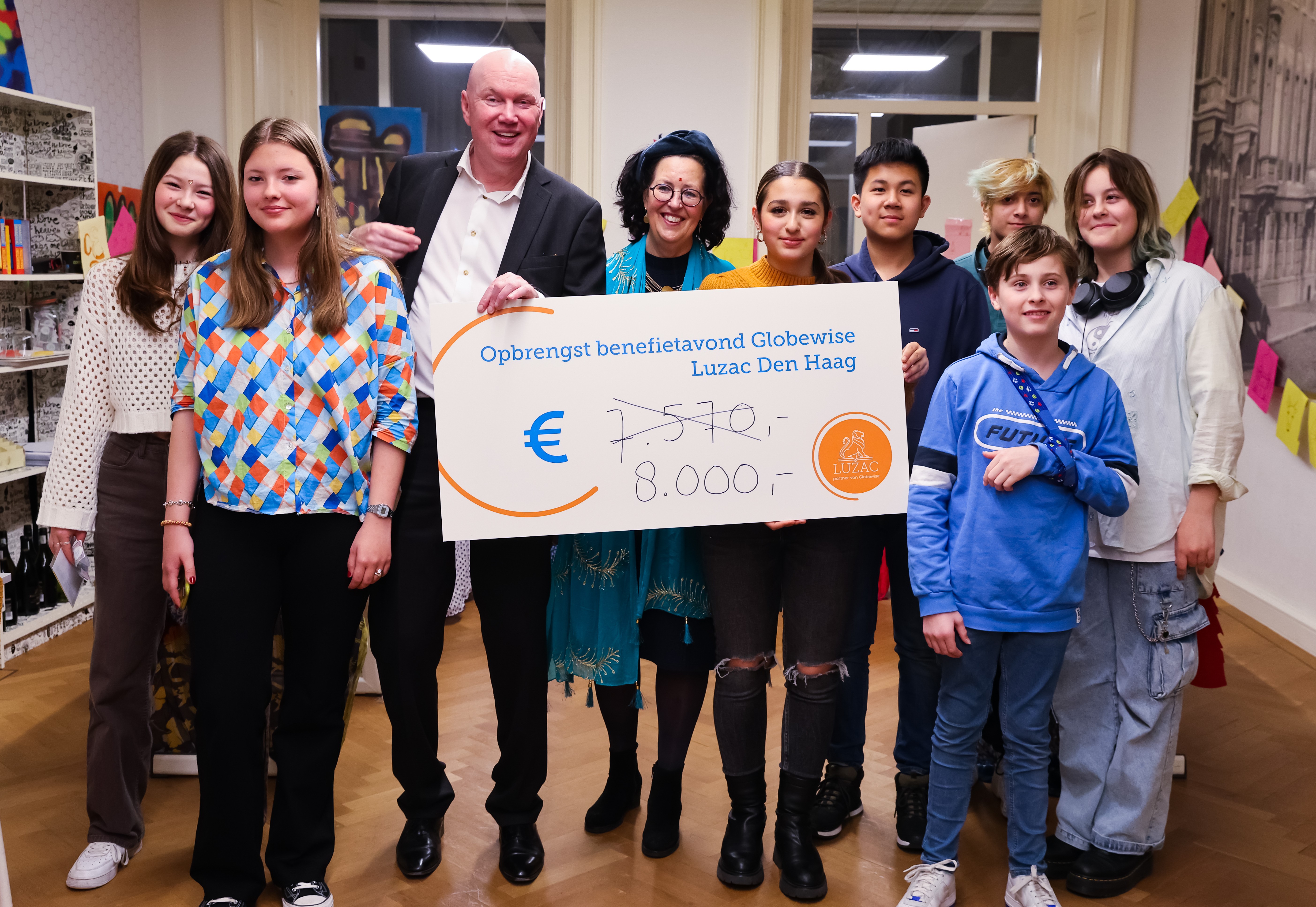 Groep mensen met cheque voor benefietavond Luzac Den Haag.