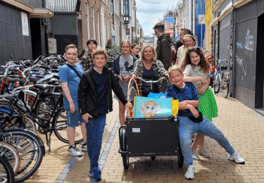 Groep mensen met bakfiets in straat in Groningen.
