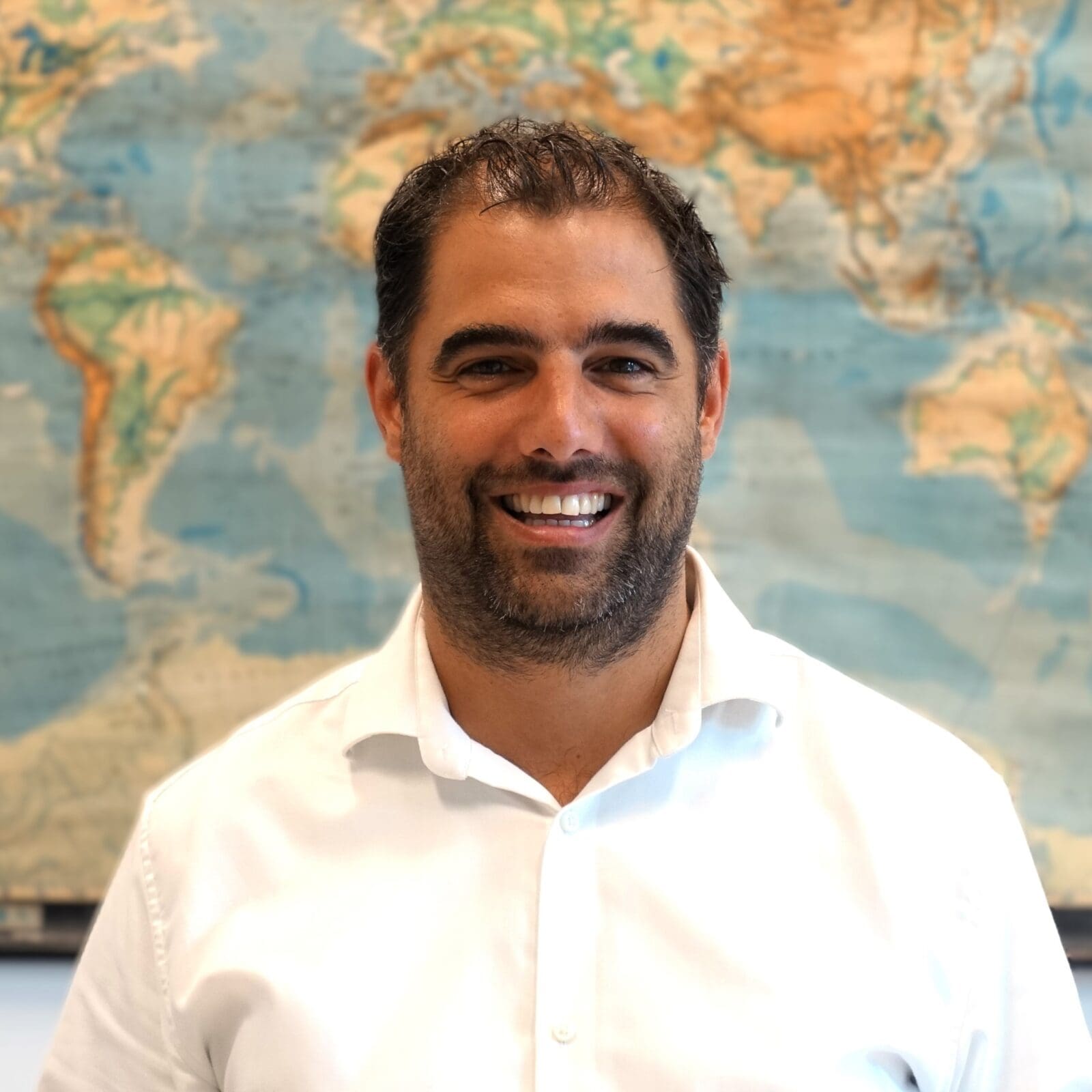 Portret van lachende man voor wereldkaart.